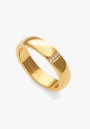 Anillo de banda de oro con una superficie lisa y pulida que presenta una fila de cinco pequeños diamantes incrustados en la parte superior.