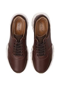 Para brązowych skórzanych sneakersów na sznurowadła z białymi podeszwami, widok z góry, z wyściełanymi kołnierzami i brandingiem "VENEZIA" wewnątrz.