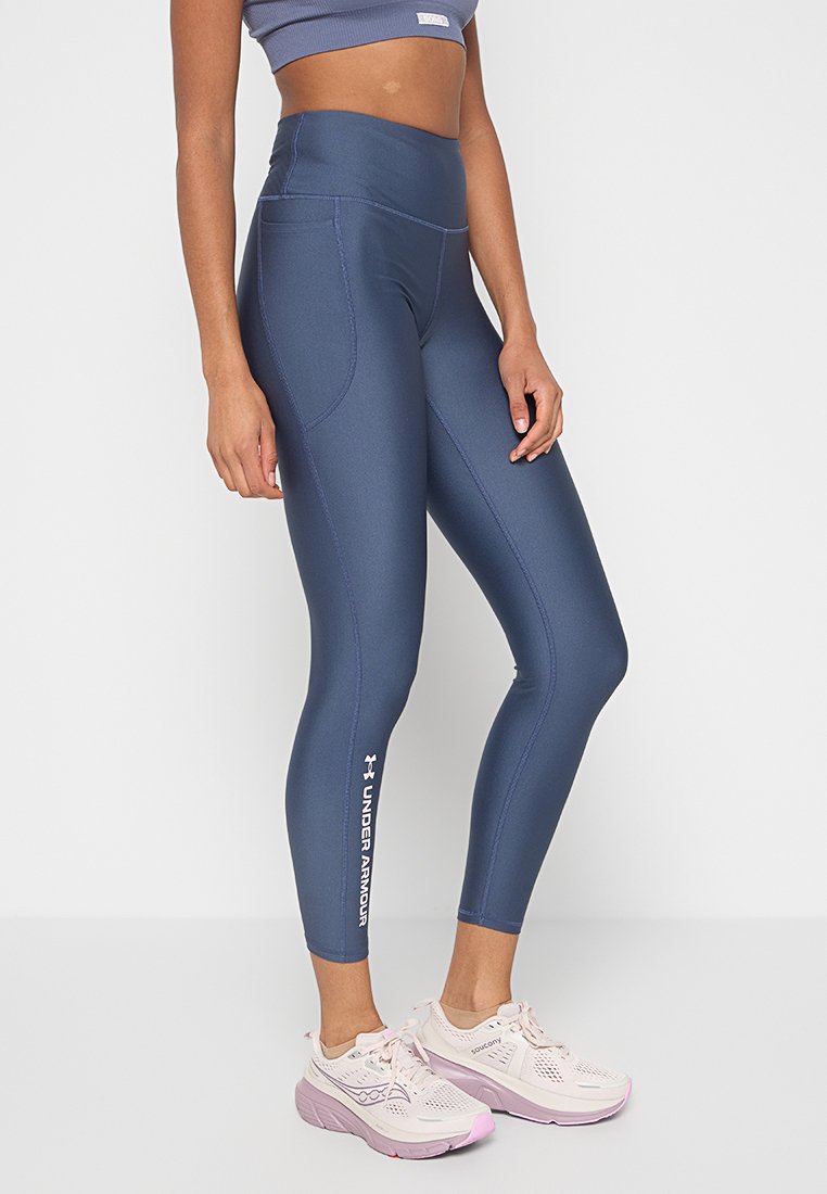 Leggings blu navy a vita alta con una texture liscia, dotati di una tasca e del logo "Under Armour" in bianco sul lato sinistro.