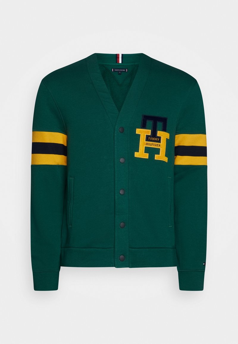 Grøn cardigan med V-halsdesign, der har gule og navy-stribede ærmer. Foran lommer og et logo-mærke. Blødt, tekstureret stof.