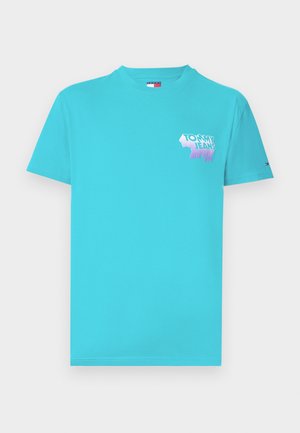 Turkos bomull T-shirt med kort ärm, med en rosa och blå "TOMMY JEANS" grafik på vänster bröstområde. Mjuk textur, rund halsringning.