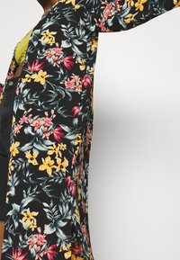 Sort floral kimono med livlige gule, pink og grønne mønstre. Let stof, lange ærmer, åben front og knælangt design.