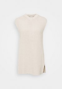 Pletený tílko v béžové barvě s vysokým límcem, žebrovanou strukturou a bočními rozparky. Vyrobeno z měkké příze pro pohodlí a prodyšnost.