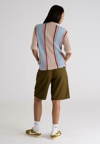Knit short-sleeve shirt with blue and beige stripes, paired with olive shorts. The shorts have side pockets and are above-the-knee length.