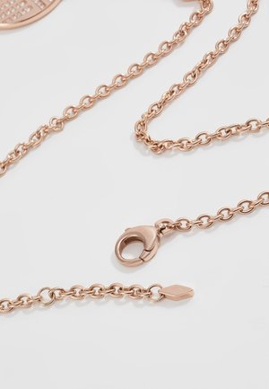 Close-up van een ketting van roségoud met een karabijnsluiting en ovale schakels op een witte achtergrond.