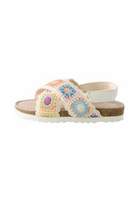 Korsett-sandaler med virkade mönster i vitt, rosa och blått, med en vadderad fotbädd och texturerad, hållbar sula.