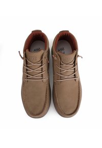Braune Lederschuhe mit runder Zehenform, kontrastierendem roten Innenfutter, gesteppten Details und Schnürdesign. Dezente strukturierte Oberfläche.
