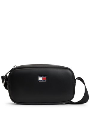 Bolso bandolera rectangular negro de Tommy Jeans con cremallera superior, correa ajustable y distintivo con el logotipo, sobre un fondo blanco.