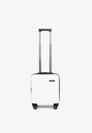 Valise rigide blanche avec une fermeture éclair noire, un télescope et quatre roues noires ; elle présente des stries horizontales et un logo sur le devant.