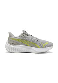 Zapatilla deportiva de color gris claro con parte superior de malla, acentos amarillos, cuello acolchado y suela de goma blanca texturizada; presenta un logo en el lado.