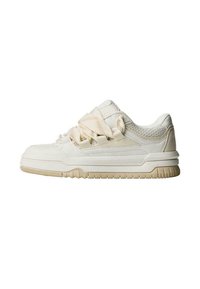 Laag uitgesneden sneaker in off-white met een gestructureerde bovenkant, mesh panelen en een contrasterende beige rubberen zool. Beschikt over dikke veters en minimale branding.