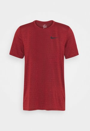 Camiseta Nike Dri-FIT de manga corta en color rojo, con un patrón texturizado sutil y el logo de Nike en negro en el pecho izquierdo.