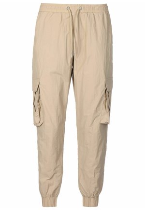 Pantalon jogger cargo beige avec taille élastique, fermeture à cordon, poches à rabat sur les côtés et poignets élastiques aux chevilles.