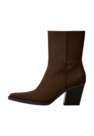 Braune Wildleder-Stiefelette mit spitzem Zehenbereich und klobigem Absatz, die ein minimalistisches Design und eine glatte Textur vor einem weißen Hintergrund zeigt.