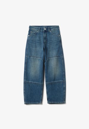 Jean en denim bleu à jambes larges avec un design en patchwork aux nuances plus claires et plus foncées, cinq poches et une fermeture par bouton à la taille.