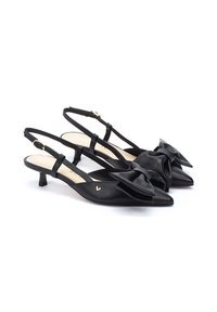 Zapatos de slingback de cuero negro con punteras puntiagudas, que presentan un prominente lazo en la parte delantera y un bajo tacón tipo kitten.