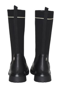 Stivali neri alti con gambale lavorato a maglia, caratterizzati da una striscia metallica e dettagli in pelle liscia. Suola in gomma rigata.