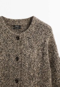Kabelstickad cardigan i brunt och svart, med rund hals, fem knappar fram och mjukt 100% kashmirmaterial.