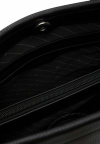 Interno di una borsa a tracolla in pelle nera con un compartimento con zip. Il tessuto interno presenta un motivo sottile con linee bianche sottili su uno sfondo nero.