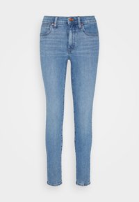 Jeans ajustados de color azul claro fabricados en denim. Presentan un diseño clásico de cinco bolsillos, un ligero desgastado y detalles de herrajes en bronce.