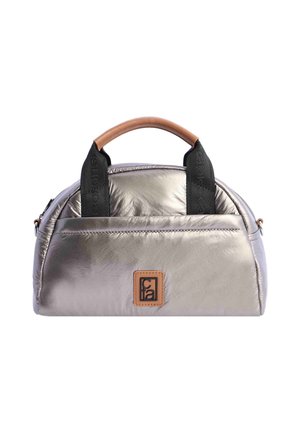 Bolso metálico plateado con forma redondeada, con un asa de cuero marrón, correas negras y un bolsillo frontal con un parche de logo.