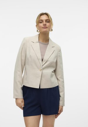 Bežna nataknuta blazer jakna z dolgimi rokavi in zobatimi reverji, ki ima enojno gumbno zapiranje. Nosimo jo čez svetlo majico in temne kratke hlače.