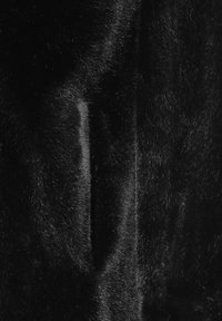 Svart konstläder tyg med en mjuk, slät textur och subtil lyster. Har varierad höjd på luden, vilket skapar djup och visuell intress.