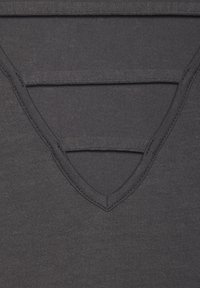 Schwarzes, V-Ausschnitt-Oberteil mit geschichtetem Design und glatter Textur. Die Nähte sind entlang des Ausschnitts und der Kanten sichtbar.