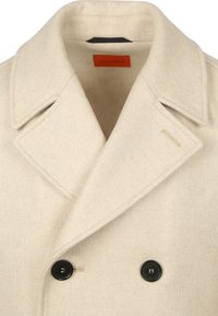 Beige dubbelzijdig jasje met een geklede kraag, voorzien van zwarte knopen en een textuurstof. Binnenlabel leest "Geschikt."