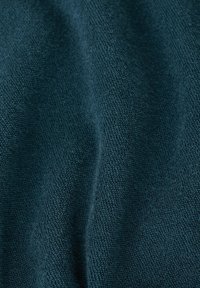 Tissu texturé en bleu sarcelle foncé avec un tissage dense en boucles et des plis subtils créant de douces ombres.