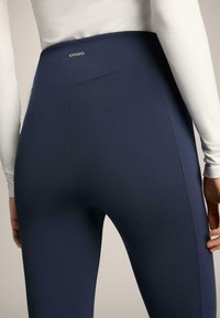 Tengerészkék, magasított derekú leggings nyújtható anyagból, sima felülettel, finom OYSHO logózással és testhezálló varrásokkal.