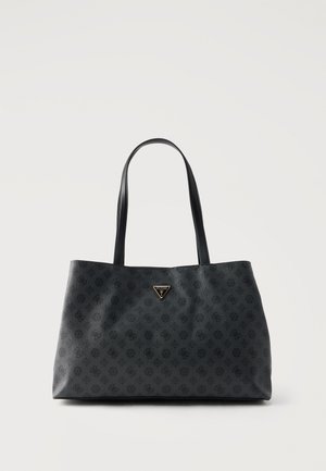 Zwarte tote tas met een gestructureerd monogrampatroon, twee dunne handvatten en een klein driehoekig Guess-logo bordje in het midden vlak bij de bovenkant.