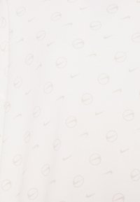 Vit träningsskjorta med en diskret heltryckt design av ljusgrå Nike-logotyper och cirkulära mönster. Slät textur, korta ärmar och rundad halsringning.
