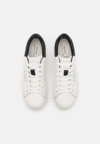 Sneakers bianchi in pelle con accentuazione nera sul tallone, punta rotonda e lacci bianchi. Presentano il logo di lato e una suola testurizzata.