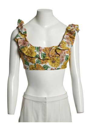 Crop top floral avec des fleurs jaunes et roses et des feuilles vertes, présentant des bretelles volantées et un décolleté carré sur un buste de mannequin blanc.