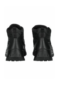 Schwarze Stiefeletten mit einem gesteppte Textiloberteil, gummierten Sohlen und einem strukturierte Absatz mit dreieckigen Mustern. Gefüttertes Innenfutter für zusätzliche Wärme.