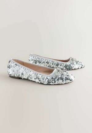 Spitze Ballerinas, die mit silbernen Pailletten bedeckt sind und einen Satinbesatz haben, mit einer kleinen Schleifenakzentierung an der Vorderseite. Flache Sohle.