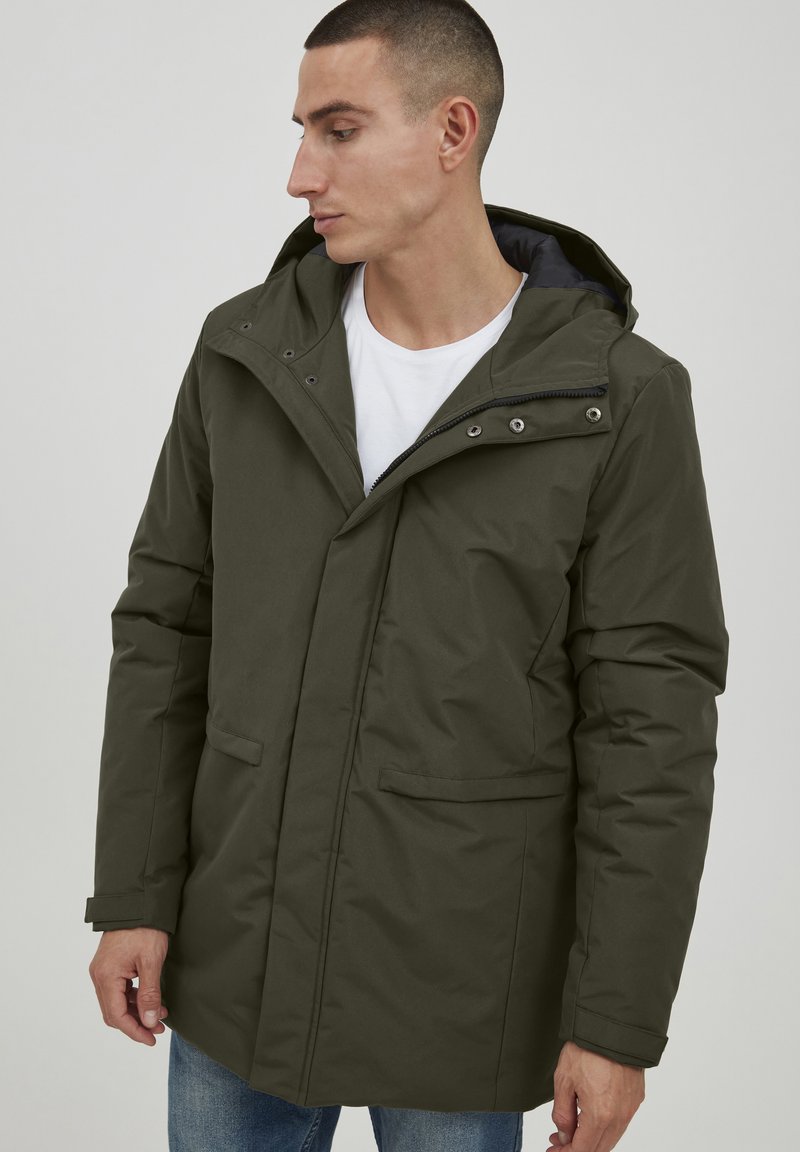 Olivenfarget isolert parka-jakke med hette, frontglidelås og trykknapper. Har to sidelommer og en glatt, matt finish.