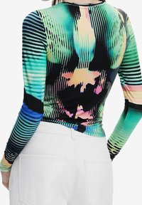 Langarmtop met een kleurrijk psychedelisch patroon, met zwarte, groene en roze tinten, gemaakt van een gladde, textuurstof.