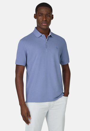 Lysblå polo-shirt med flat krave og tre-knap lukning; har et lille logo på brystet og korte ærmer.