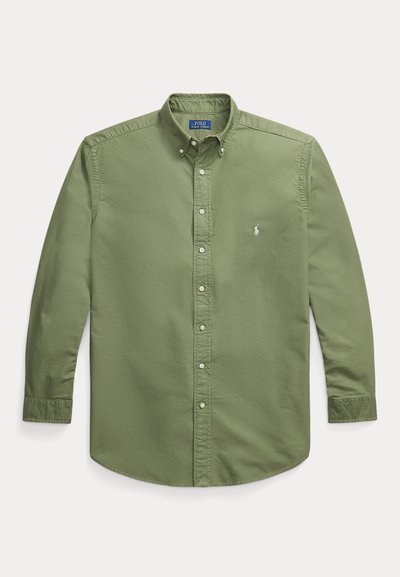 Dlhá zelená olivová košeľa na gombíky s golierom na gombíky a malým bielym vyšívaným logom na ľavej strane hrude.