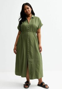 Grünes, knopfbares Midikleid mit kurzen Ärmeln, elastischem Bund und Schlitz vorne. Hergestellt aus einem leichten Stoff, bietet es eine lockere Passform.