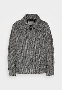 Kurtka z wełny z dużym kołnierzem, z diagonalnym czarno-białym wzorem, z zapięciem na guziki i bocznymi kieszeniami. Teksturowana powierzchnia.