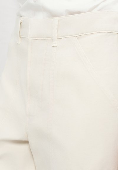 Beige broek met een gladde textuur, met een rechte pijpdesign, riemlussen en subtiele stiksels rond de zakken en naden.