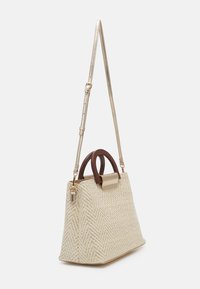 Beige woven handbag with a herringbone pattern. Features a gold metallic strap, brown top handles, and a structured shape.