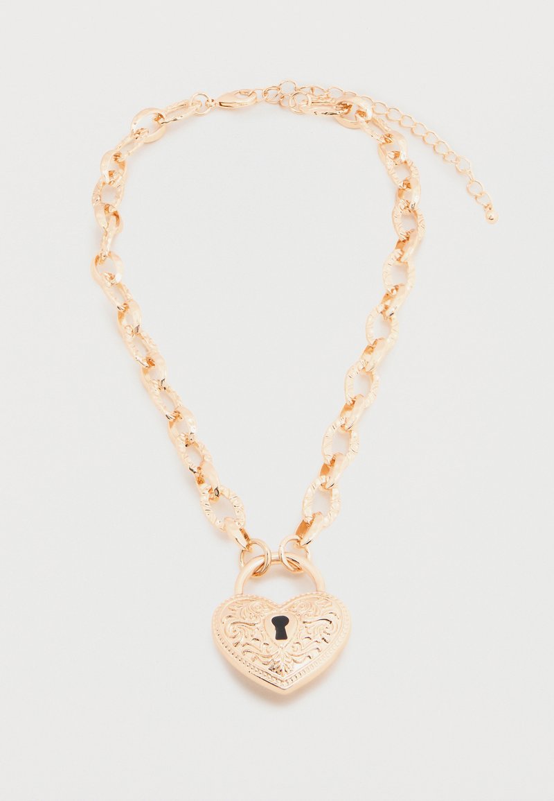 Collier chaîne en ton or avec de grands maillons texturés et un pendentif en forme de cadenas cœur orné d'un motif floral gravé et d'une serrure.