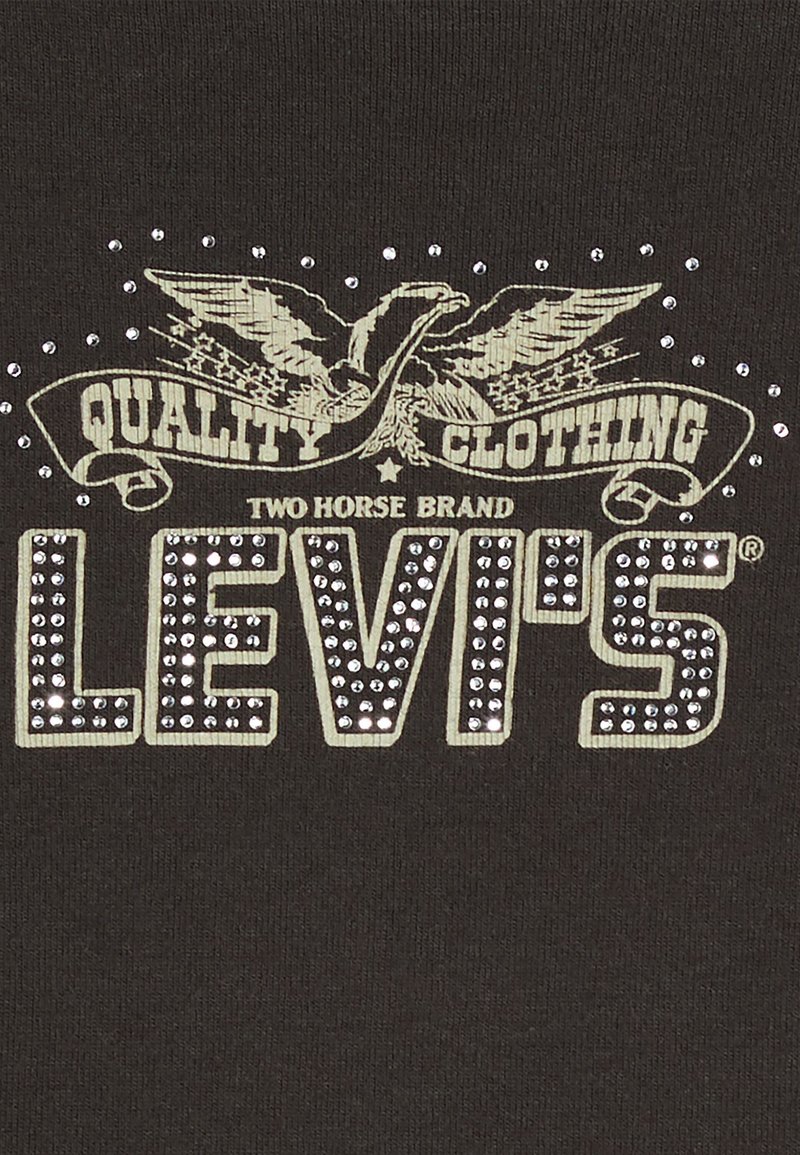T-shirt noir avec un graphique texturé comprenant des clous en argent, un motif d'aigle et "LEVI'S" en lettres majuscules.