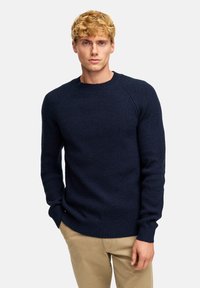 Marineblaues Rippstrickpullover mit rundem Ausschnitt und langen Ärmeln, aus einem strukturierten Stoff mit gerippten Bündchen und Saum.