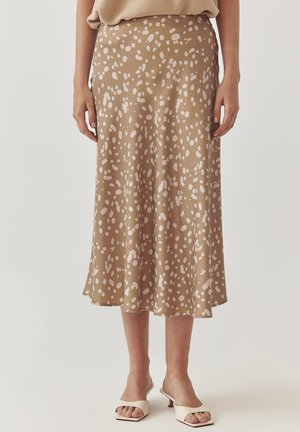 Beige midi-hame valkoisilla abstrakteilla täplillä. Virtaava muotoilu, sileä pinta ja helma, joka loppuu hieman polven alapuolelle.