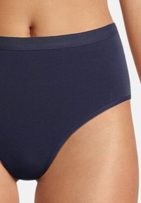 Marineblaue, hoch-taillierte Panty aus weichem, dehnbarem Material mit einem glatten Bund und Saum. Nahtloses Design für Komfort und Passform.
